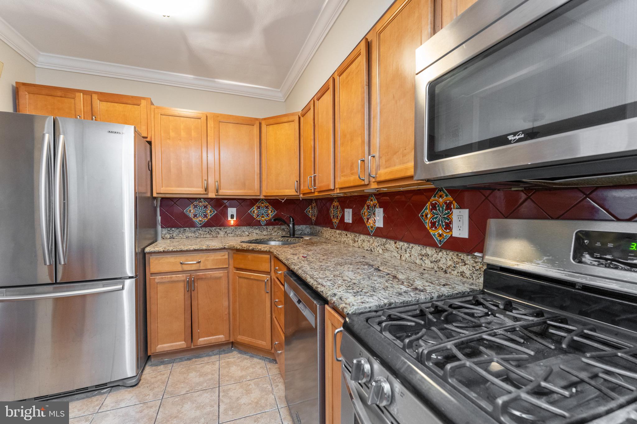 1609 Brisbane Street Silver Spring, MD 20902 - Photo 7 of 25 a kitchen with stainless steel appliances granite countertop a sink stove and refrigerator