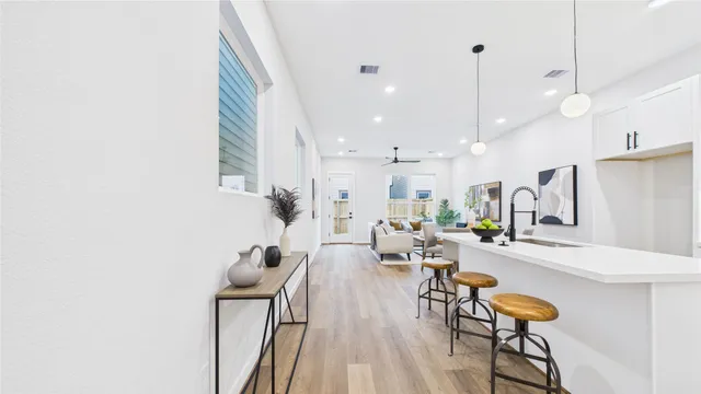 a kitchen with a sink a stove and chairs with white walls