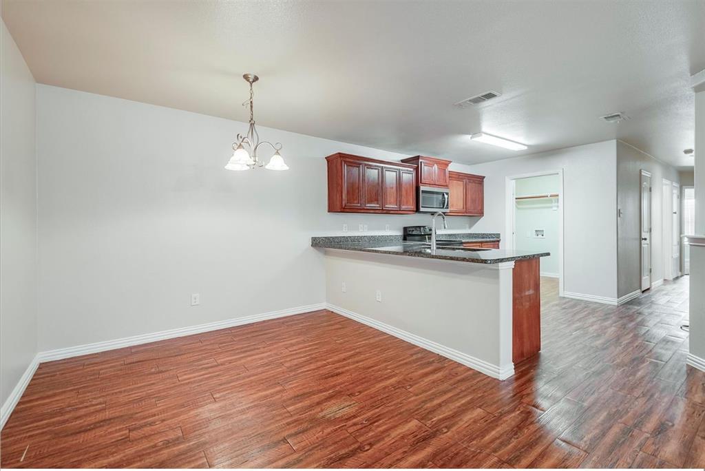 452 Canvas Court Crowley, TX 76036 - Photo 3 of 11 a kitchen with kitchen island granite countertop a stove and a wooden floor