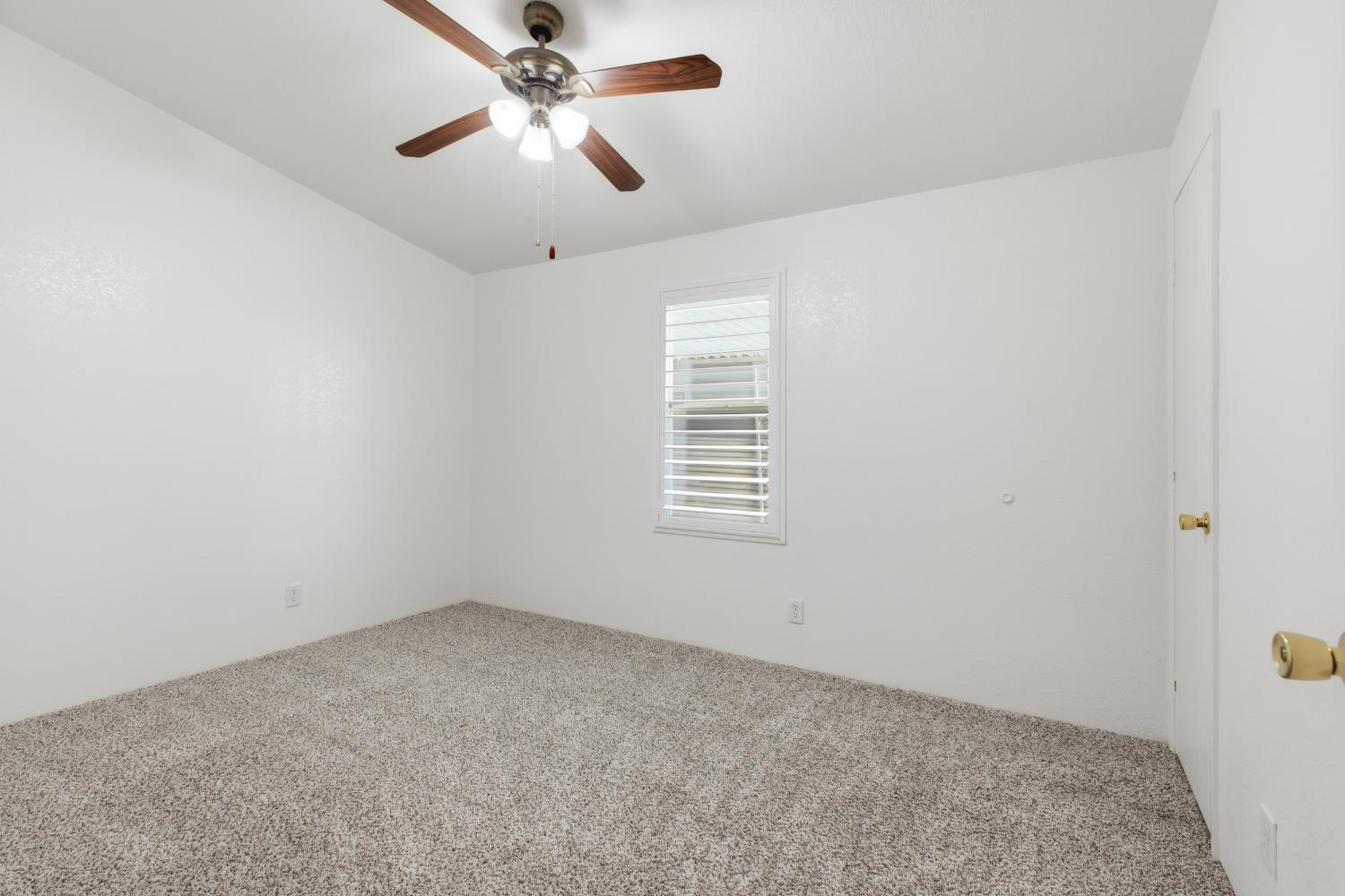 2113 Barrington Lane Modesto, CA 95350 - Photo 14 of 32 an empty room with a window and a fan