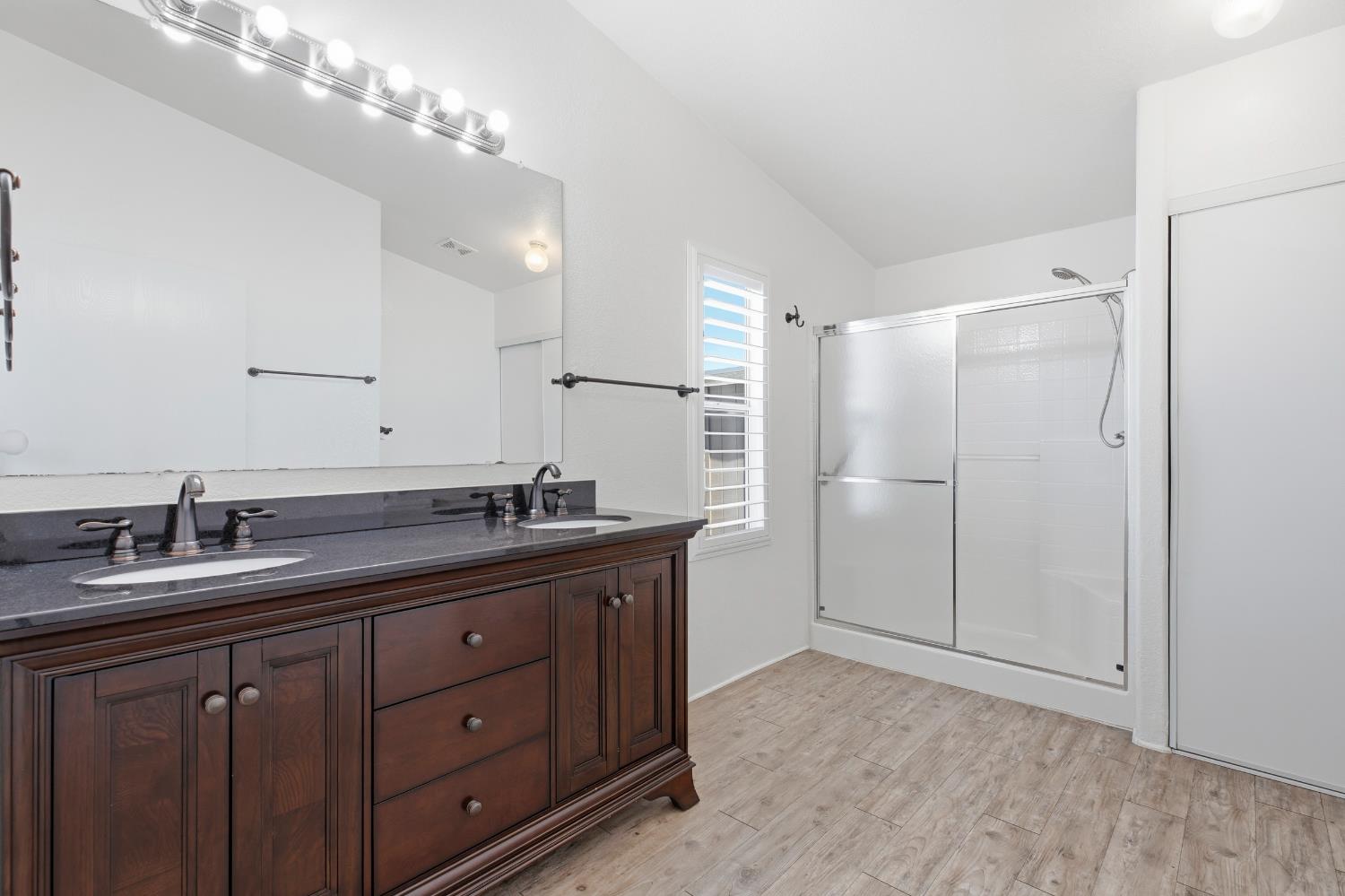 2113 Barrington Lane Modesto, CA 95350 - Photo 17 of 32 a bathroom with a granite countertop sink a large mirror and a shower