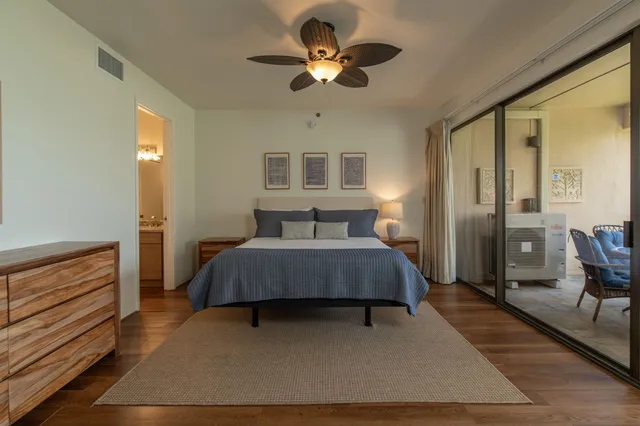 a bedroom with a bed chandelier and a window