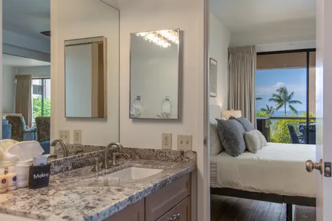 a bathroom with a granite countertop sink and a mirror