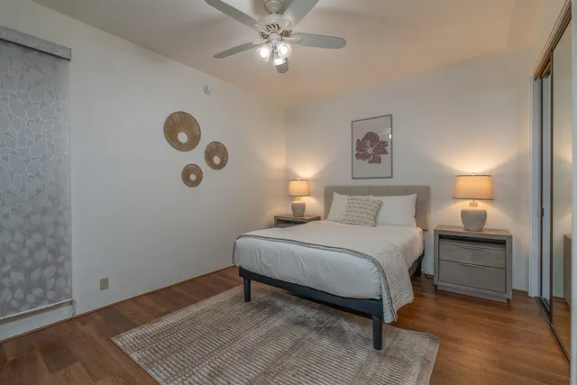 a spacious bedroom with a bed and a lamp