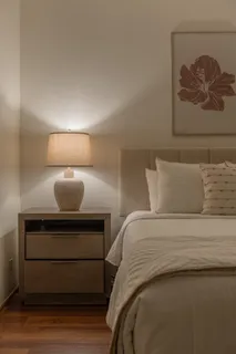 a bedroom with a bed and a lamp on dresser