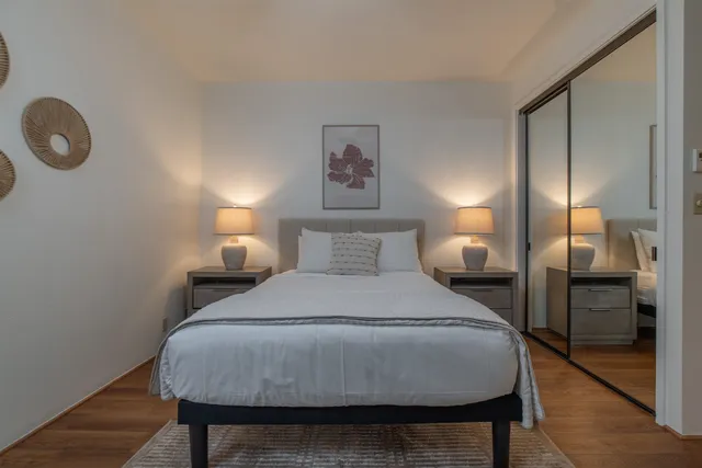 a bedroom with a bed and painting on the wall