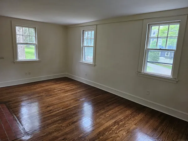 a view of a room with wooden floor and a window