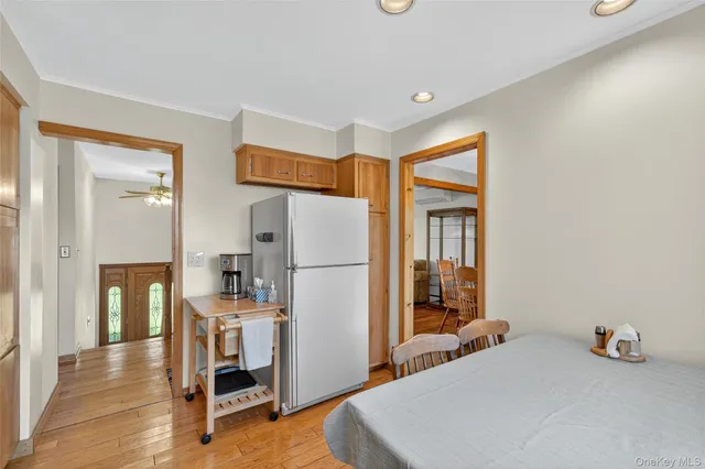 a bedroom with a bed and a refrigerator