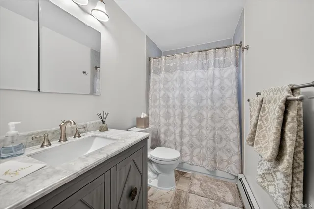 a bathroom with a granite countertop sink a toilet and a mirror