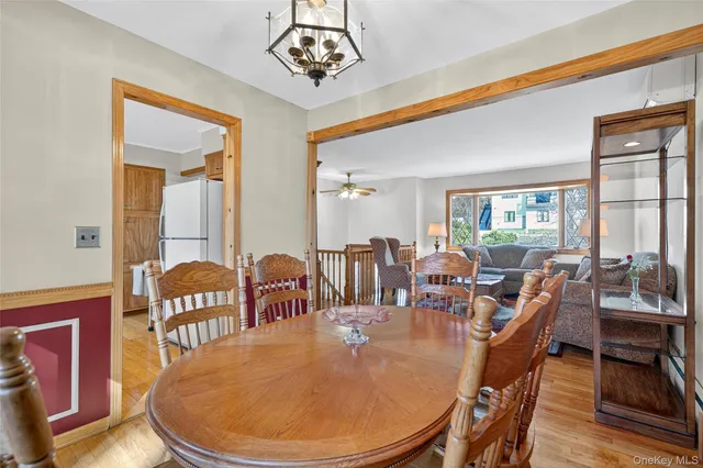 a dining room with furniture a chandelier and wooden floor