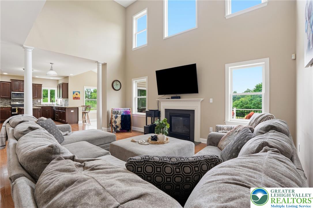 1212 Miller Road Wind Gap, PA 18091 - Photo 15 of 72 A spacious great room features vaulted ceilings, warm hardwood floors, and a modern fireplace.