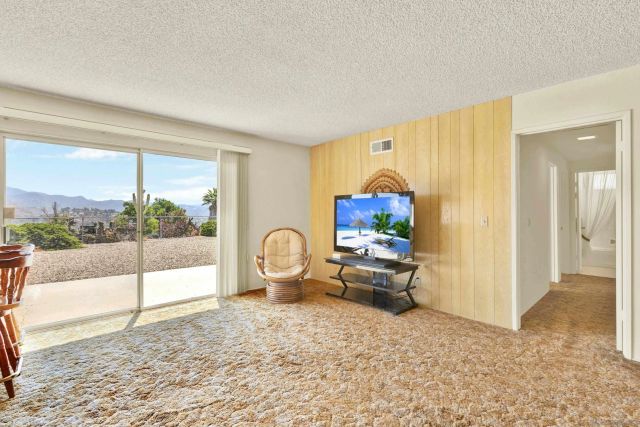 a living room with furniture a window and a flat screen tv