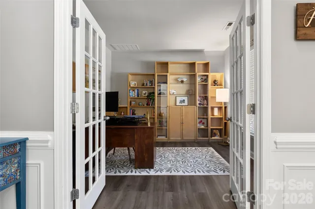 a view of a hallway with wooden floor and living room