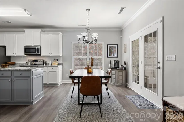 a kitchen with a dining table chairs and refrigerator