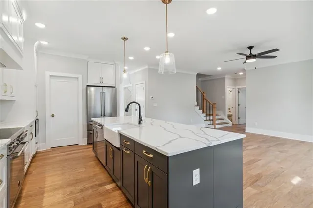 a large kitchen with kitchen island a sink a center island a stove and a chandelier