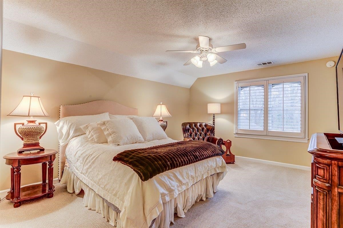 6648 Rue Beaumonde Drive Memphis, TN 38120 - Photo 14 of 20 a bedroom with a bed and a chandelier