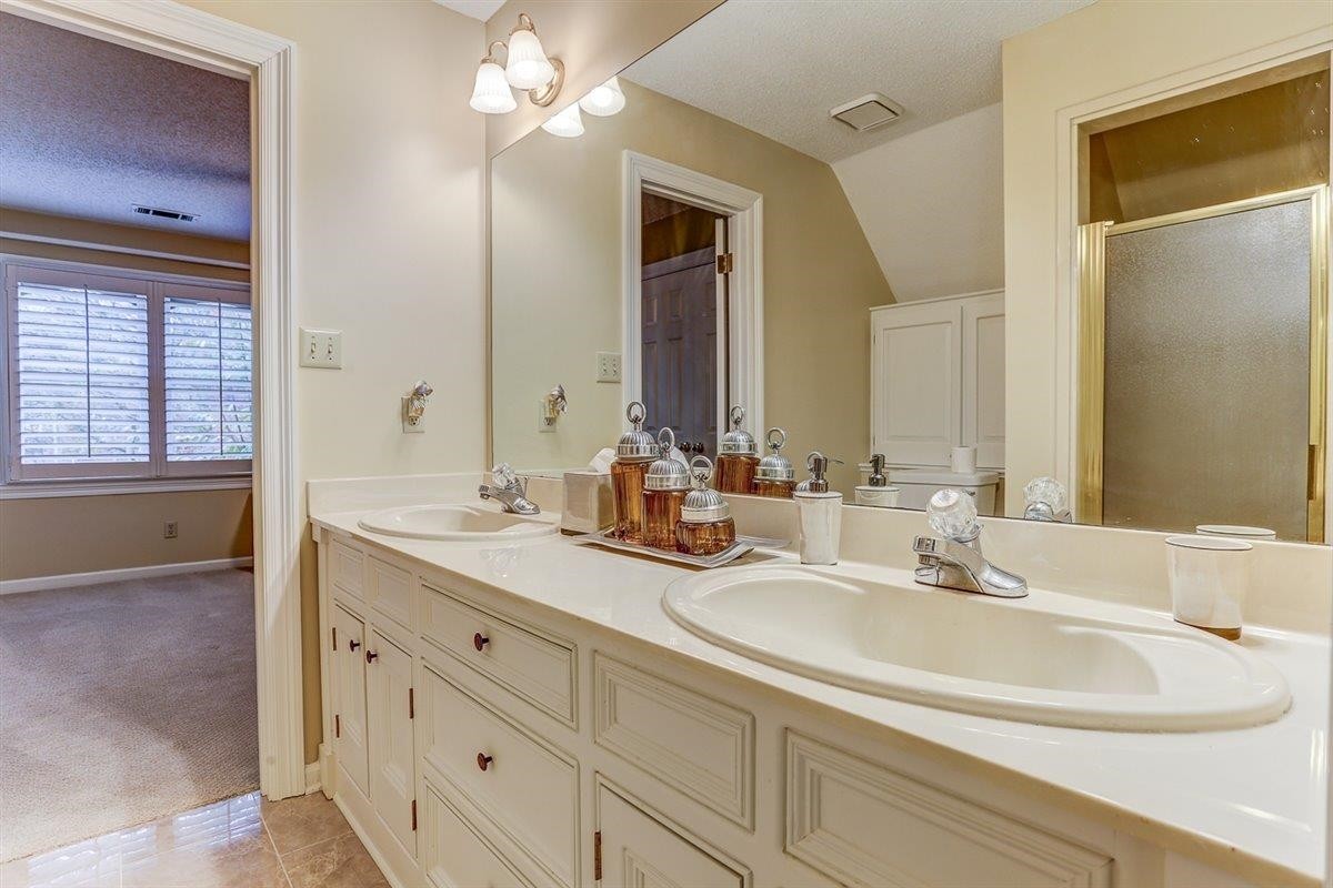 6648 Rue Beaumonde Drive Memphis, TN 38120 - Photo 17 of 20 a bathroom with double vanity sinks and a mirror