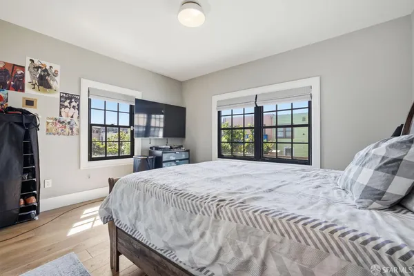 a room with a white bed and wooden floor