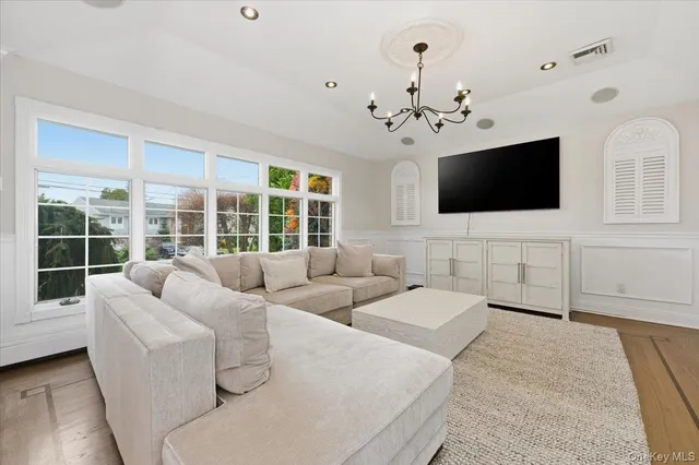 a living room with couches a flat screen tv and a large window