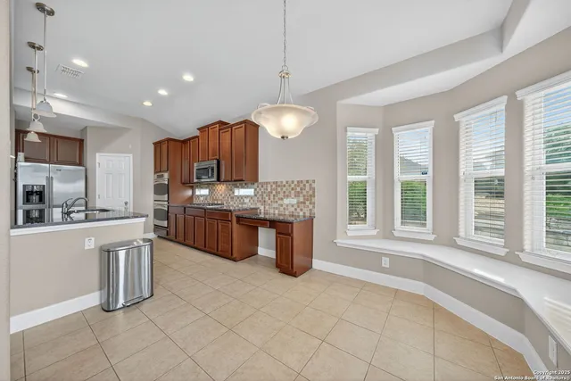 a large kitchen with kitchen island granite countertop a large counter top and stainless steel appliances