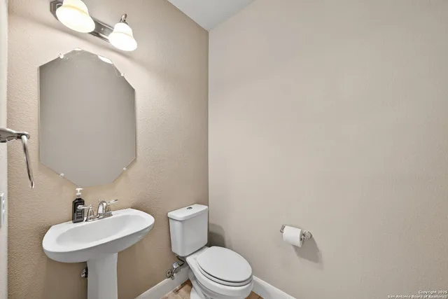 a bathroom with a toilet sink and mirror