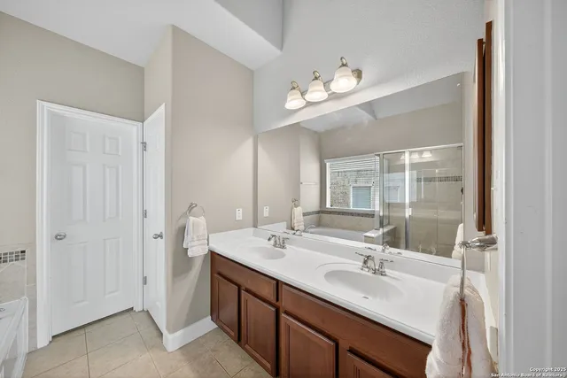 a bathroom with a double vanity sink a mirror and a shower