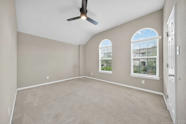 an empty room with windows and fan