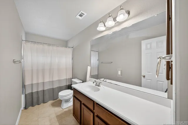 a bathroom with a sink a toilet a mirror and shower