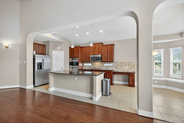 a kitchen with stainless steel appliances granite countertop a refrigerator and a stove top oven