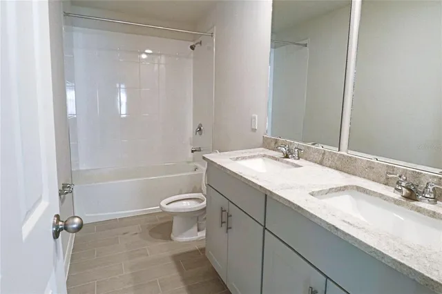 a bathroom with a granite countertop sink a toilet and shower