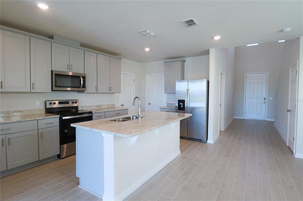 902 Rivers Crossing Street Clermont, FL 34714 - Photo 2 of 26 a kitchen with a sink a counter top space stainless steel appliances and cabinets