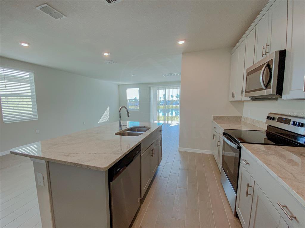 902 Rivers Crossing Street Clermont, FL 34714 - Photo 4 of 26 a kitchen with stainless steel appliances granite countertop a stove a sink and a refrigerator