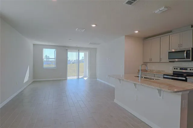 a kitchen with granite countertop white cabinets and window