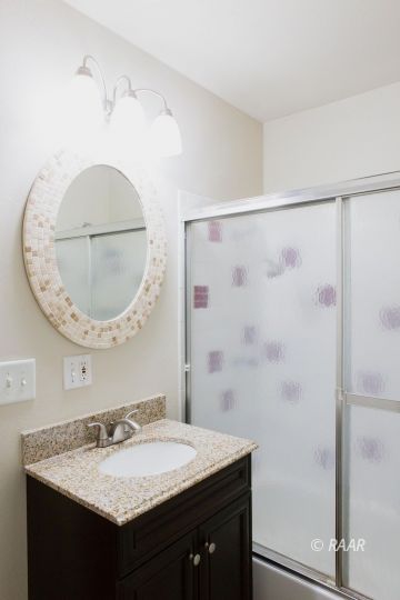 401 Marlene Court Ridgecrest, CA 93555 - Photo 26 of 30 a bathroom with a granite countertop sink a mirror and a shower