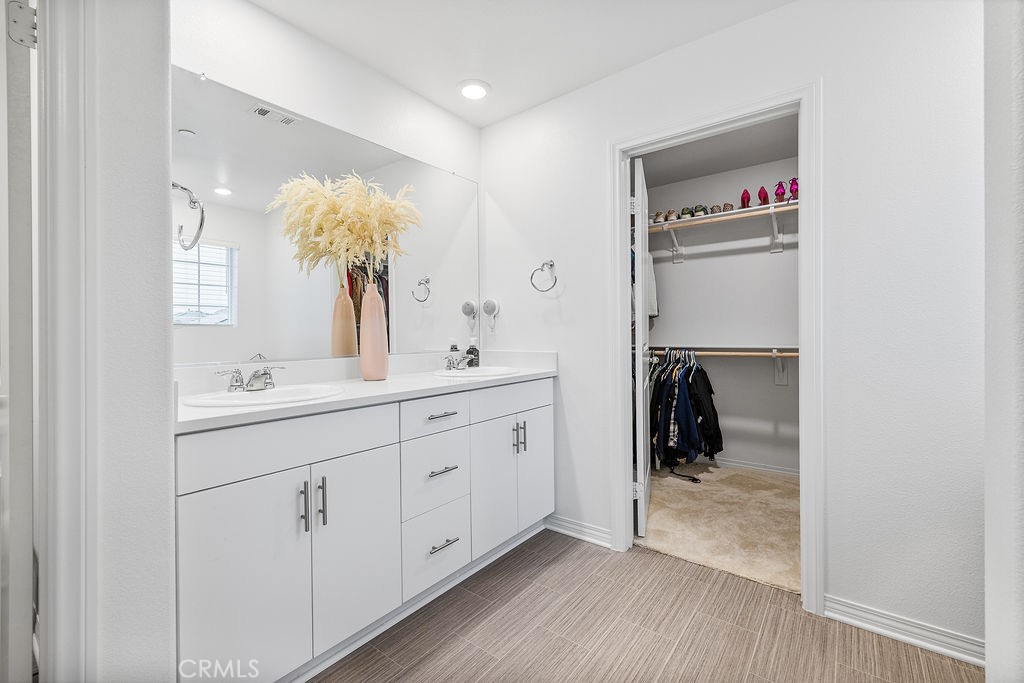 2522 Gunner Ridge Way Rialto, CA 92377 - Photo 16 of 40 a en suite bathroom with a sink double vanity and a mirror