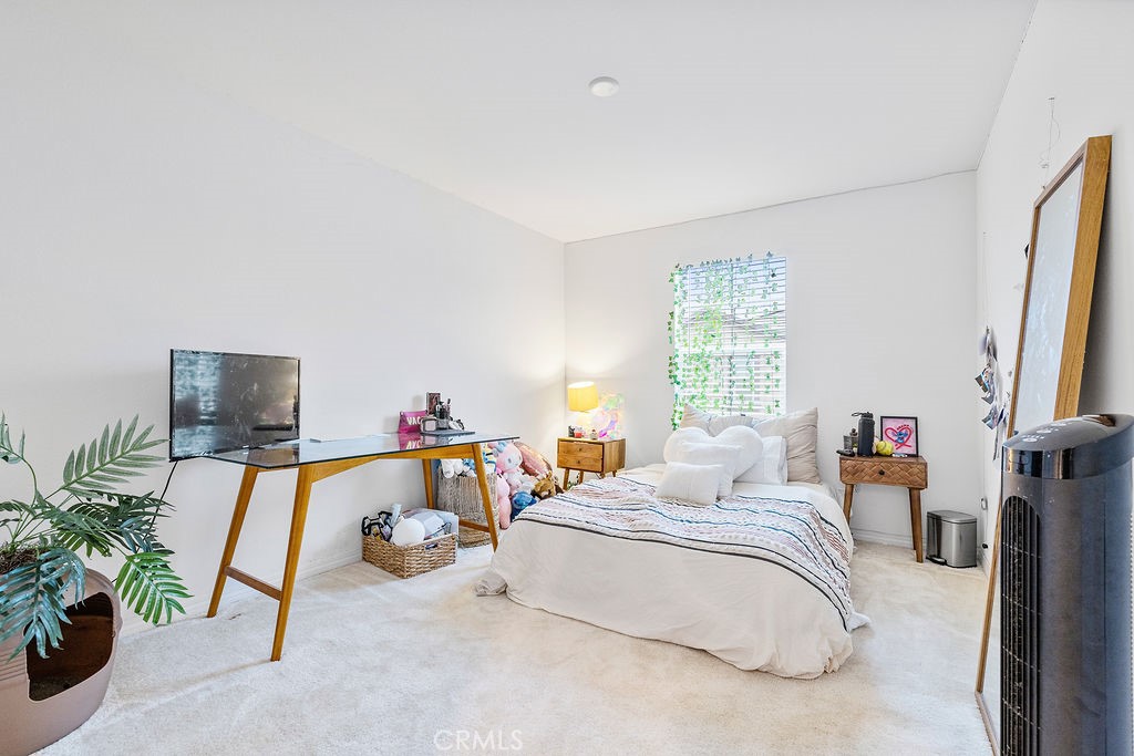 2522 Gunner Ridge Way Rialto, CA 92377 - Photo 18 of 40 a bedroom with a bed and a flat tv screen on the dresser