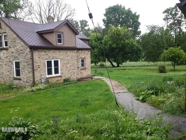 4422 Broadview Road Rockford, IL 61101 - Photo 19 of 25 a view of a brick house with a big yard potted plants and large tree