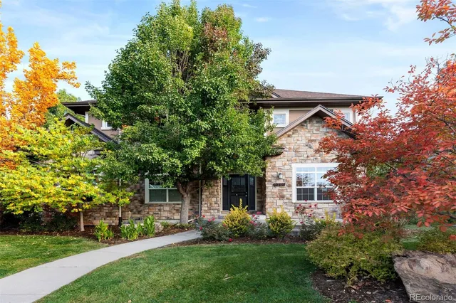 front view of a house with a yard and a tree
