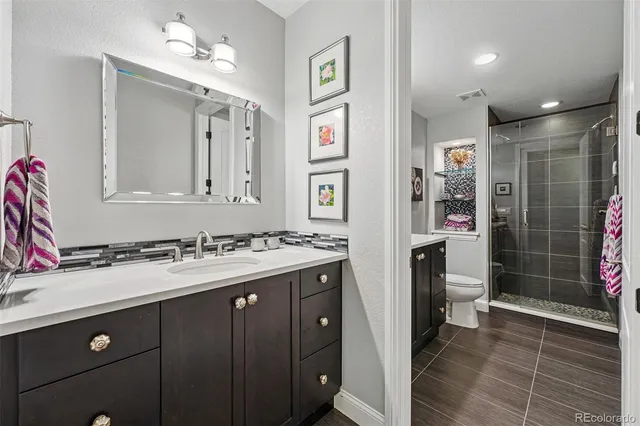 a bathroom with a sink vanity granite shower and a mirror