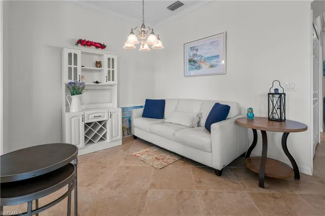 a living room with furniture a chandelier and a dining table