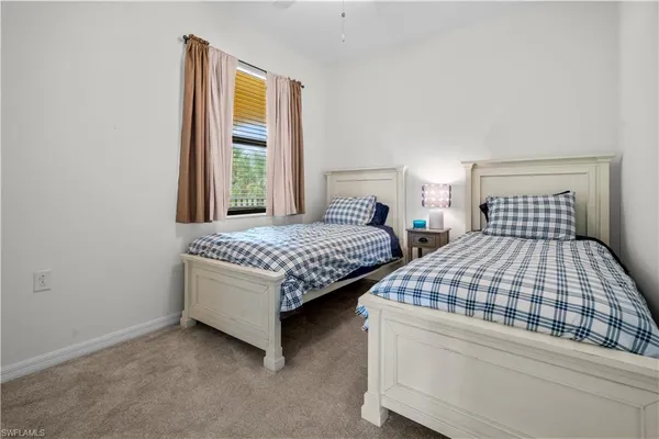a bedroom with two beds and a window
