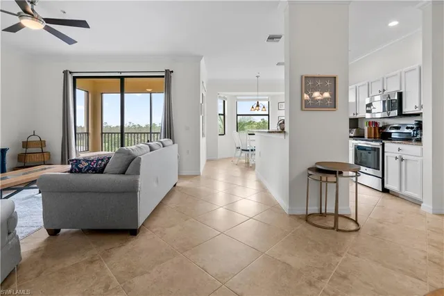 a living room with furniture a chandelier and a dining table