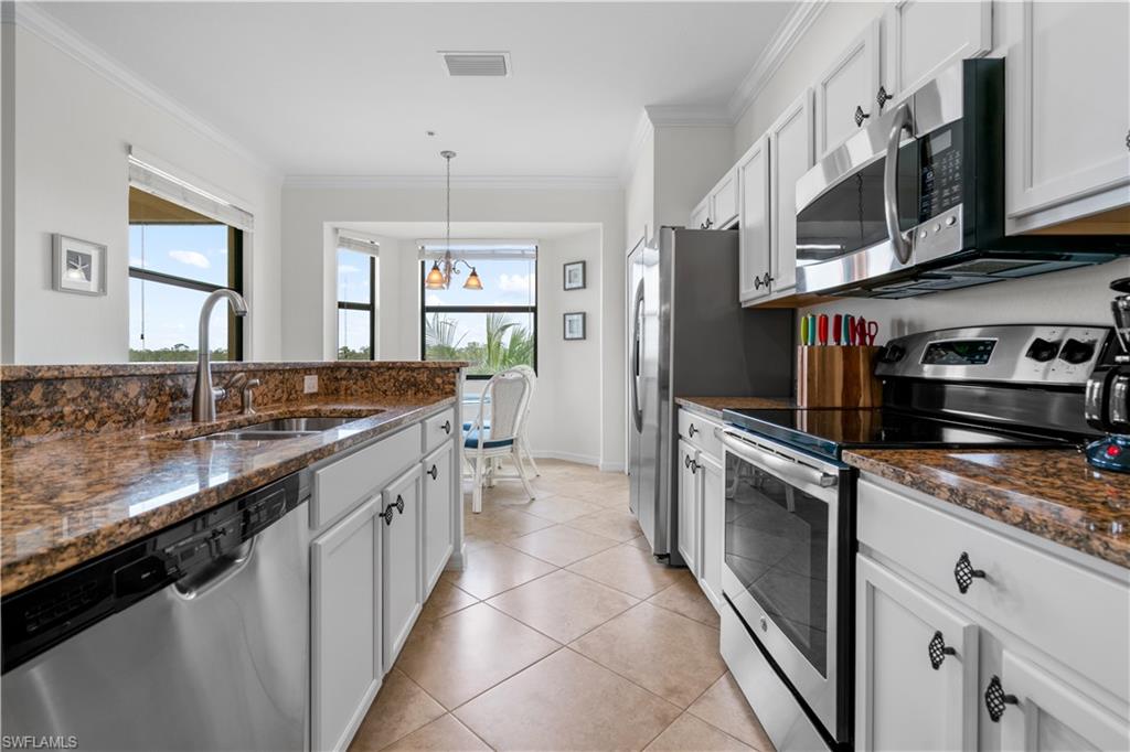 9735 Acqua Court, Unit 641 Naples, FL 34113 - Photo 5 of 34 a kitchen with stainless steel appliances granite countertop a sink stove and cabinets