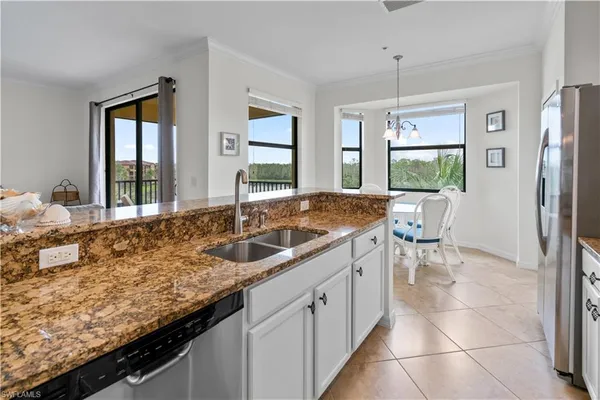 a kitchen with granite countertop a sink and a refrigerator