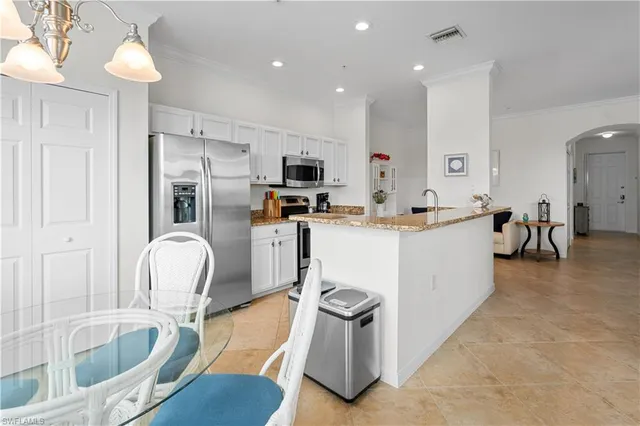 a living room with furniture a flat screen tv and kitchen view