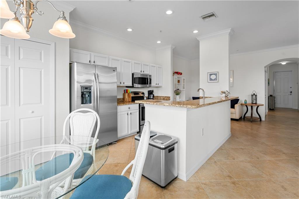 9735 Acqua Court, Unit 641 Naples, FL 34113 - Photo 10 of 34 a living room with furniture a flat screen tv and kitchen view