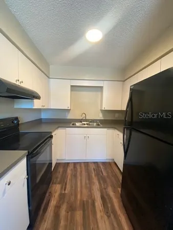 a kitchen with granite countertop a stove and a sink