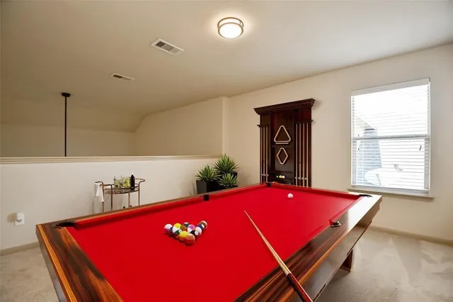 a room with pool table and windows