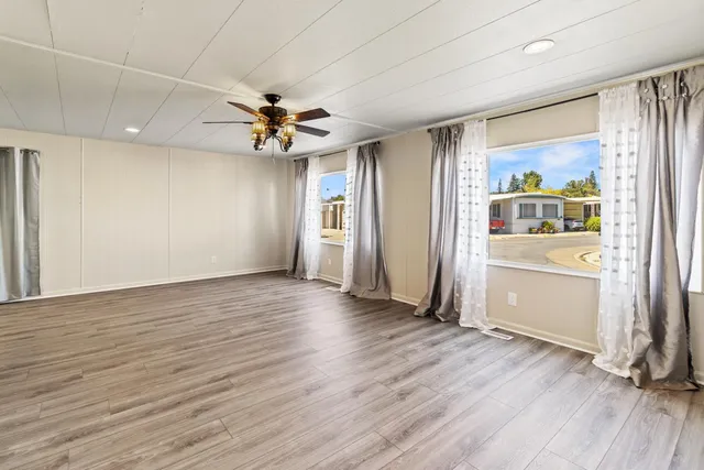 an empty room with wooden floor and windows