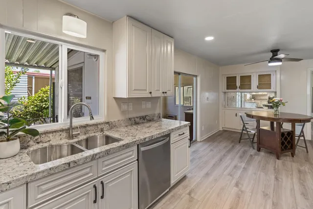 a kitchen with stainless steel appliances granite countertop a sink a stove and a microwave